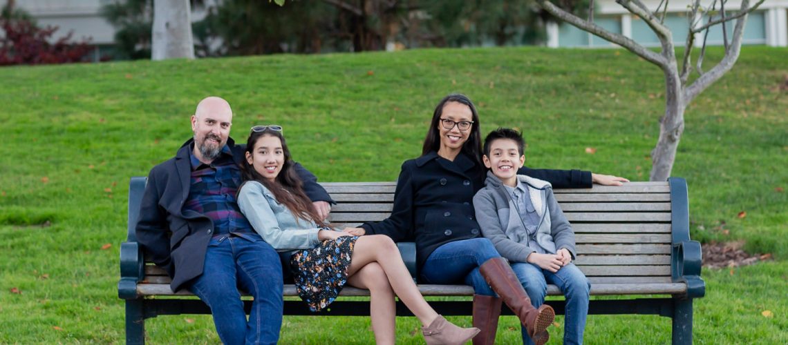 family of four sits on a bench in letterman digital arts garden